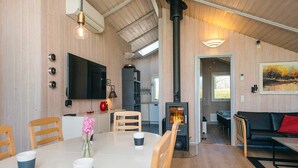 A modern interior with a dining area, a living room, a fireplace, and a television. - Holiday Home in Sydals (Sydals)