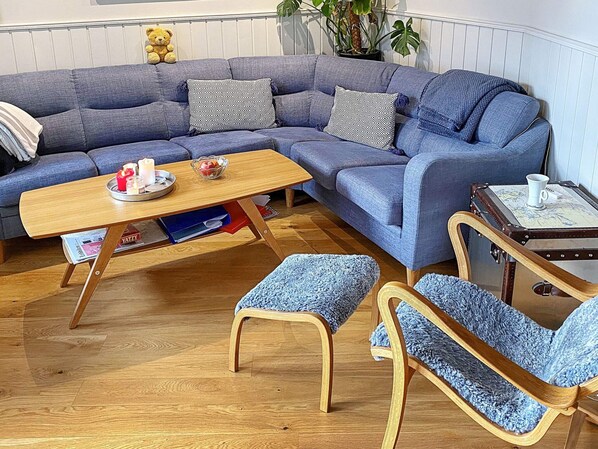 A modern living room with a blue sofa, wooden coffee table, and matching armchairs. - 4 Star Holiday Home in Stromstad (Stromstad)