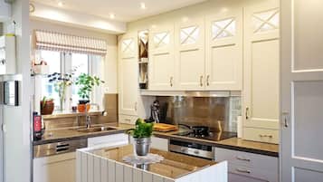 Una cocina moderna con armarios blancos, electrodomésticos de acero inoxidable y una isla central.