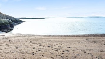 Una playa con costa rocosa y primer plano de guijarros.