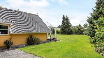 A residential property with a sloped roof, a covered porch, and a well-maintained lawn.