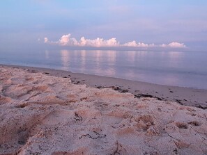 A beach with a sandy foreground and calm water reflecting clouds. - Holiday Home in VÃ¦ggerlÃ¸se (Vaeggerlose)