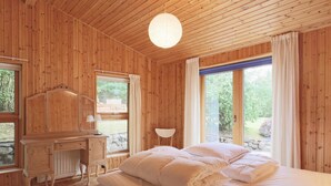 A wooden room with a bed, a desk, and a window. - 6 Person Holiday Home in Gilleleje (Gilleleje)