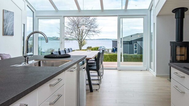 Een moderne keuken met een groot schiereiland, een inbouwfornuis en uitzicht op de omgeving.