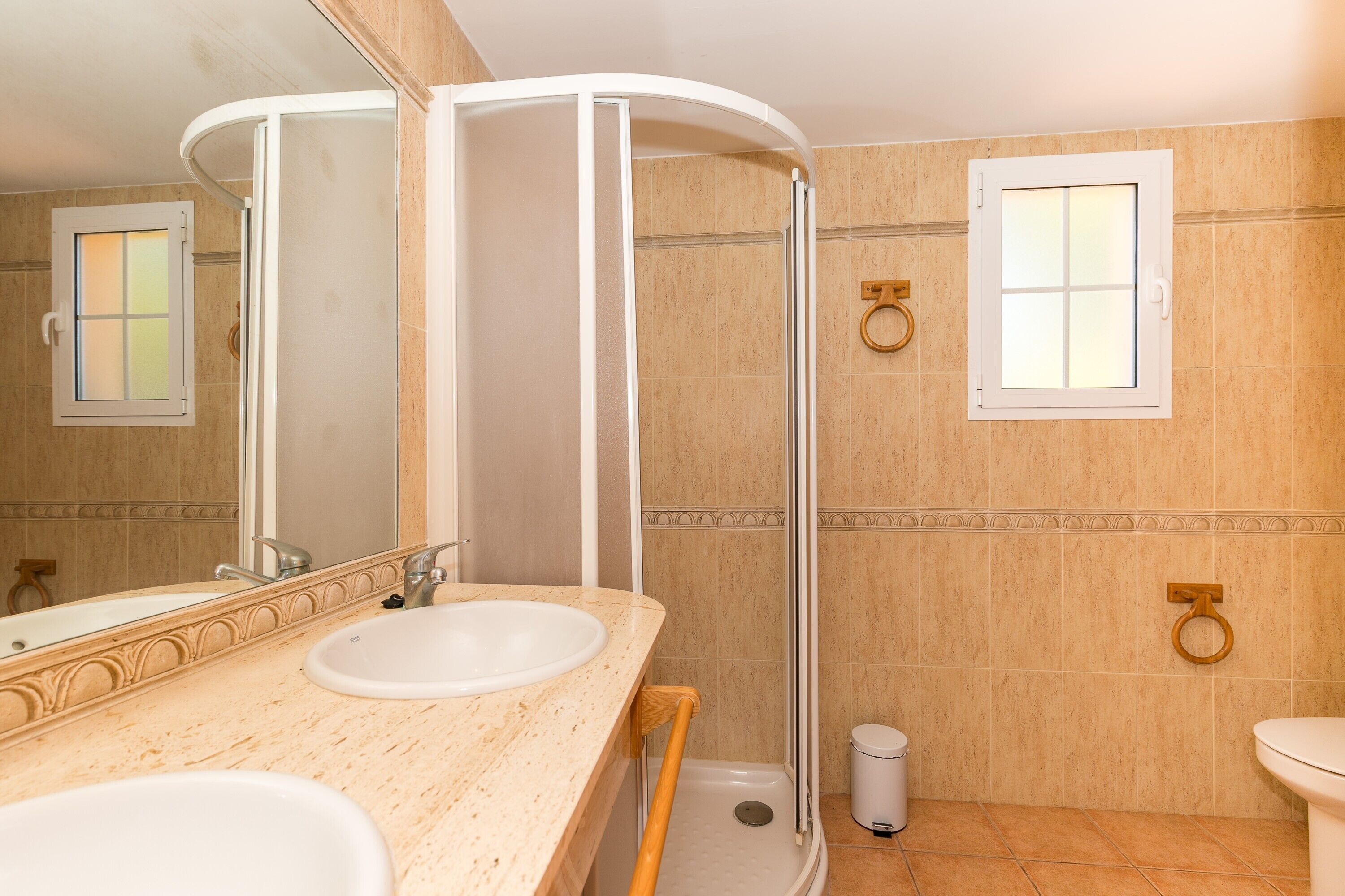 Un baño con dos lavamanos, ducha e inodoro.