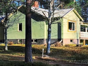 A two-story building with a green facade, a visible window, and a small balcony.