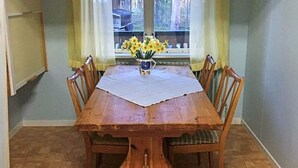 A wooden dining table with a white tablecloth, surrounded by wooden chairs. - 6 Person Holiday Home in Rorbacksnas (Lima)