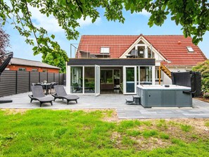 A modern house with a patio, outdoor seating, and a hot tub. - 8 Person Holiday Home in Henne (Henne)