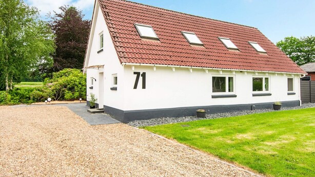 A two-story house with a red-tiled roof, numbered 71, and a gravel driveway. - 8 Person Holiday Home in Henne (Henne)