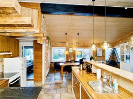Una cocina moderna con detalles de madera, una isla grande y vistas al exterior.