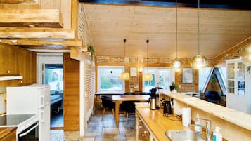Una cocina moderna con detalles de madera, una isla central e iluminación colgante.