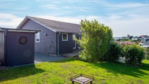 A single-story house with a sloped roof, a fenced yard, and a small shed. - 5 Person Holiday Home in Hejls (Hejls)