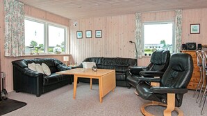 A cozy living room with a black leather sofa, a wooden coffee table, and a leather recliner. - 5 Person Holiday Home in Hejls (Hejls)