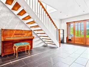 A grand piano, a staircase, and a view of the outdoors. - 4 Star Holiday Home in Fitjar (Fitjar)