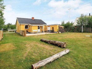 A yellow house with a patio and a stack of firewood in the yard. - Holiday Home in LÃ¦sÃ¸ (Læsø)