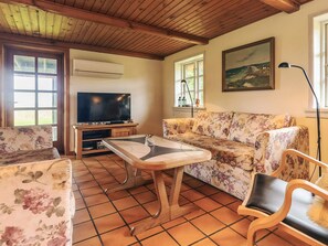 A living room with a television, sofa, and a coffee table.