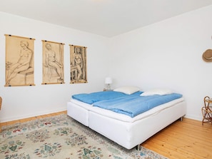 A bedroom with a bed, a patterned rug, and three wall-mounted artworks. - 6 Person Holiday Home in Hjorring (Hjørring)