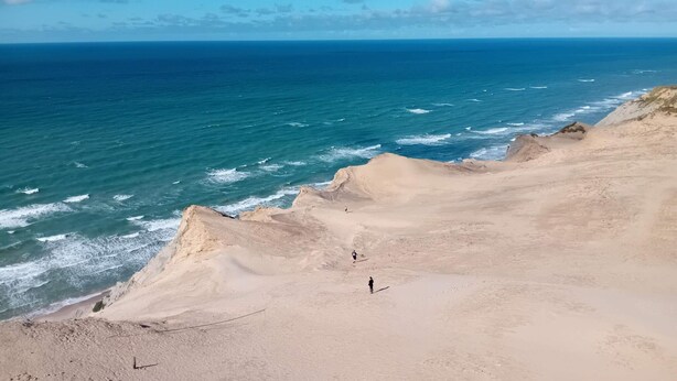 Un paisaje costero con playa arenosa y olas del océano.