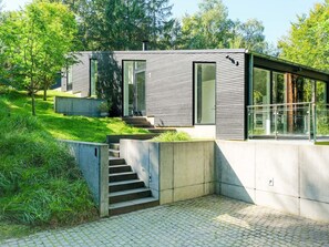 A modern building with a concrete staircase leading to a glass door entrance.
