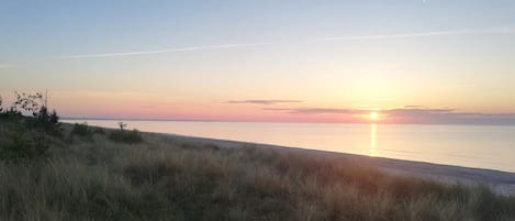 A beach with a sunset over the water.