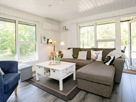 Una sala de estar acogedora con un sofá seccional, una mesa de centro y un sillón azul.
