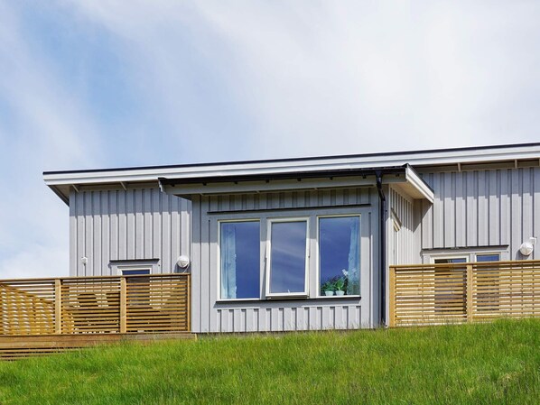 A modern building with a flat roof, large windows, and a wooden fence. - 4 Star Holiday Home in Stromstad (Stromstad)