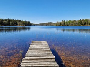 A wooden dock extending into a calm lake surrounded by dense forest. - 4 Person Holiday Home in Bralanda (Bralanda)