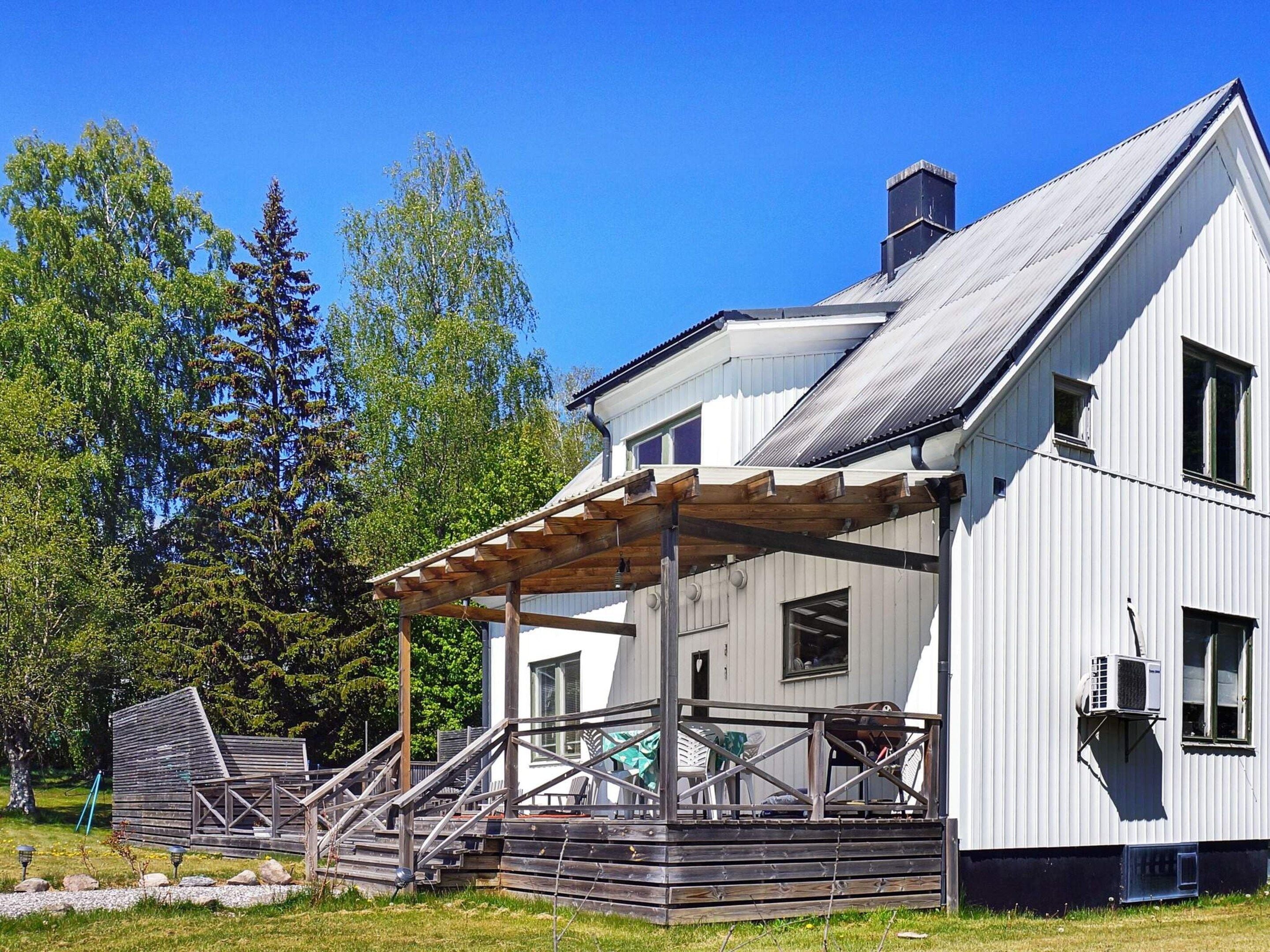 A two-story white building with a covered porch and a chimney.