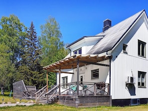 A two-story white building with a covered porch and a chimney.