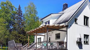 A two-story house with a covered porch and a chimney.