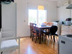A compact kitchen with a dining table, chairs, a microwave, and a refrigerator. - 7 Person Holiday Home in Billingsfors (Billingsfors)