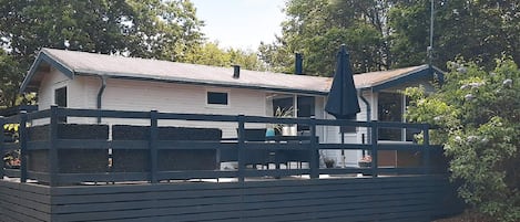 A two-story building with a balcony, surrounded by a wooden fence.