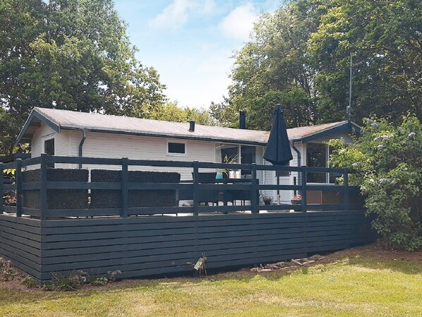 A two-story building with a balcony, surrounded by a wooden fence.