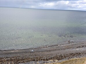 Un paysage côtier offrant une vue dégagée sur la mer et une plage de sable.
