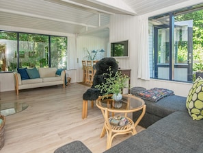 A modern living room with a sofa, a round coffee table, and a large window. - 5 Person Holiday Home in Grenaa (Grenaa)