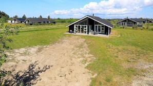 Ein modernes Haus mit einer großen Terrasse und einem Feldweg, der dorthin führt.