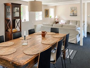 A dining area with a wooden table, chairs, and a cabinet with glass doors.