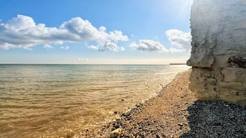Una playa con costa rocosa y cielo despejado.