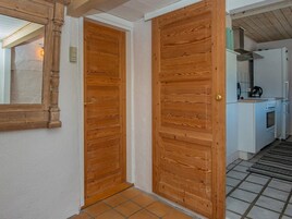 Un pasillo con puertas de madera que dan a una zona de cocina.