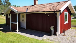 A small, single-story building with a red exterior and a tiled roof. - 4 Person Holiday Home in Ucklum (Ucklum)