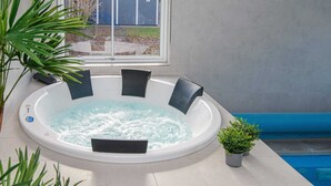 A hot tub with a view of a swimming pool and a window. - Holiday Home in Juelsminde (Juelsminde)