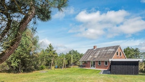 A house with a sloped roof, a brick exterior, and a fenced yard. - 6 Person Holiday Home in Glesborg (Glesborg)