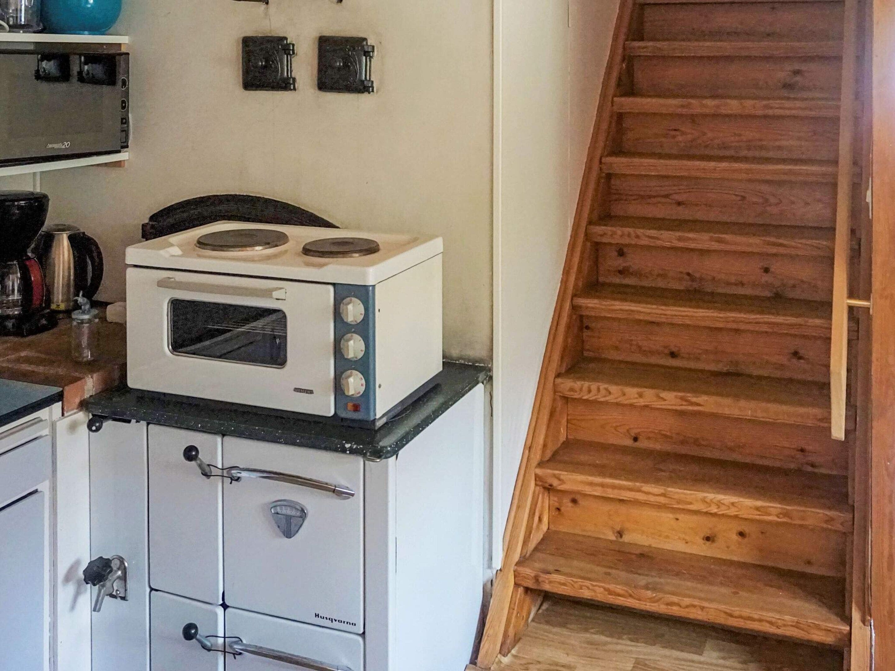 Una cocina con estufa, horno y alacenas.