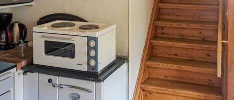 Una cocina con estufa, horno y alacenas.