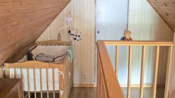 A room with a crib, a small table, and a teddy bear.