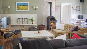 A cozy living room with a sofa, a coffee table, and a fireplace.