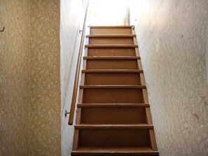 Stairs lead upwards with a metal railing for support.