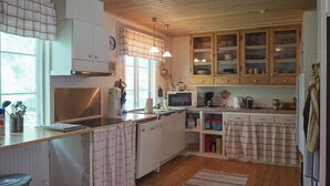 A kitchen with wooden cabinets, a microwave, and a sink.
