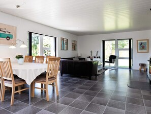 A modern living space with a dining area, a sofa, and a kitchen area. - Holiday Home in VÃ¦ggerlÃ¸se (Vaeggerlose)