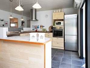 A modern kitchen with a central island, stainless steel appliances, and pendant lighting. - Holiday Home in VÃ¦ggerlÃ¸se (Vaeggerlose)